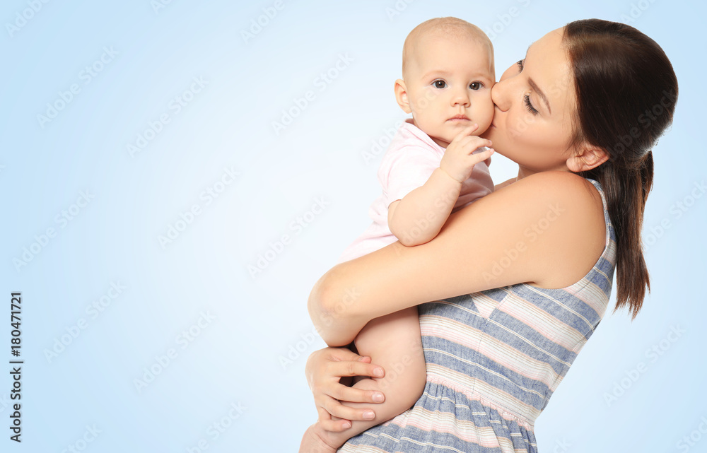 Portrait of happy young woman with cute baby on color background Portrait of happy young woman with cute baby on color background