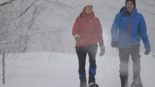 A shot of the uperbodys two snowshoers walking side by side turns to their lowerbodys 