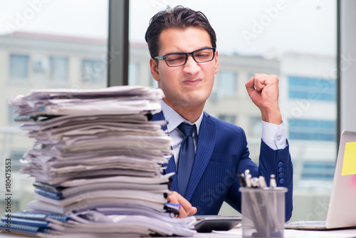 Workaholic businessman overworked with too much work in office