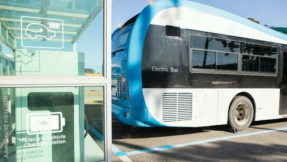 Electric bus stands at the charging station. His lights flash. Camera zoom moves forward. 4K video