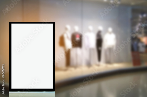 vertical advertising billboard or blank showcase light box for your text message or media content in front of men fashion clothes shop showcase in shopping mall, sale, commercial and marketing