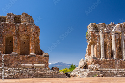 Ruins and columns of antique greek theater in Taormina and Etna Mount in the background. Sicily, Italy, Europe.