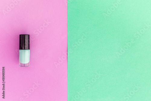 Colorful cosmetics on colorful background. Mint nail polish on pink and mint background top view copyspace
