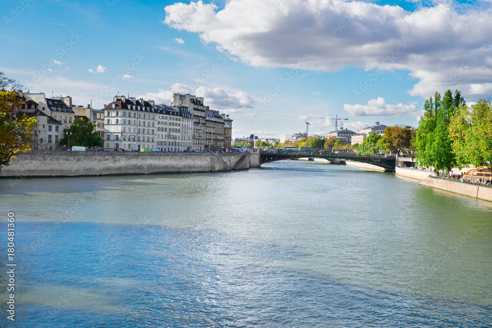 Pont au Double bridge and river Seine waters, blue sky with clouds, Paris, France