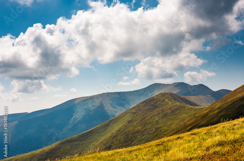 rolling hills of Borzhava mountain ridge in summer. wonderful nature background with grassy slopes under the cloudy sky