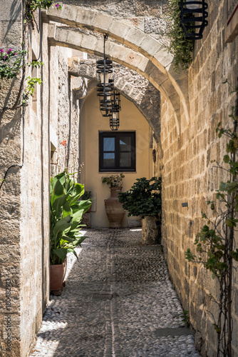 Fototapeta Naklejka Na Ścianę i Meble -  Small narrow street with ancient arches and walls in Rhodes town. Rhodes island., Greece