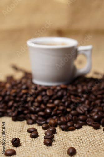 Cup of coffee on sackcloth with coffee beans