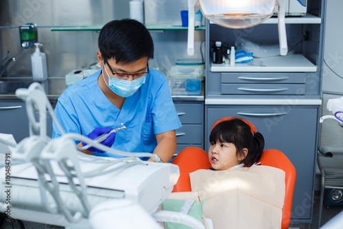 Little girl looking cautious at the dentist. Doctor and his young patient. Pediatric dentistry  introduction to dentistry  prevention dentistry concept