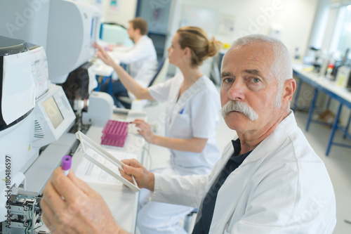 senior doctor examines a medical record in the hospital room