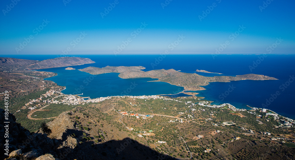 Panoramic view of the gulf of Mirambello with Spinalonga island. View from the mountain of Oxa with ruins of ancient water tanks, Crete, Greece. Panoramic view of the gulf of Mirambello with Spinalonga island. View from the mountain of Oxa with ruins of ancient water tanks, Crete, Greece.