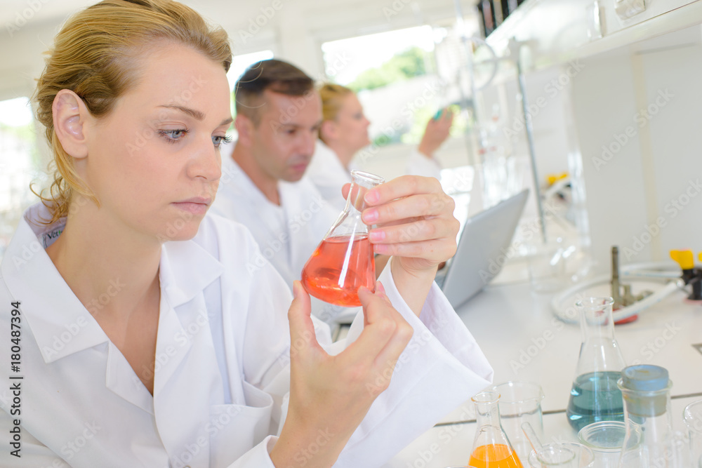 Female lab technician holding glass flask Female lab technician holding glass flask
