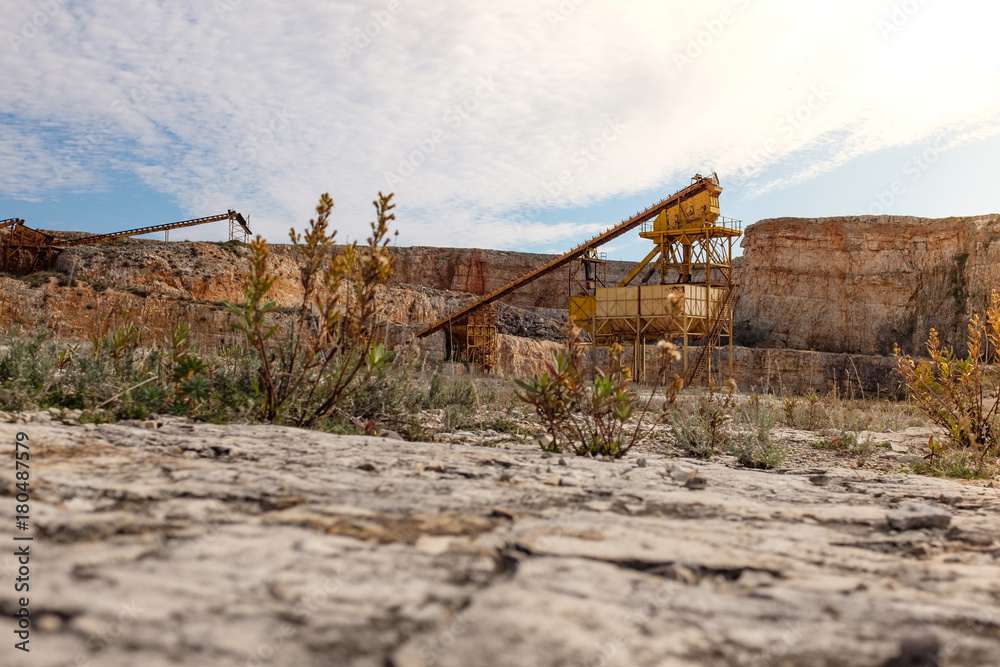Former stone quarry with abandoned crusher and conveyor machines. Apulia region, Italy. Former stone quarry with abandoned crusher and conveyor machines. Apulia region, Italy.