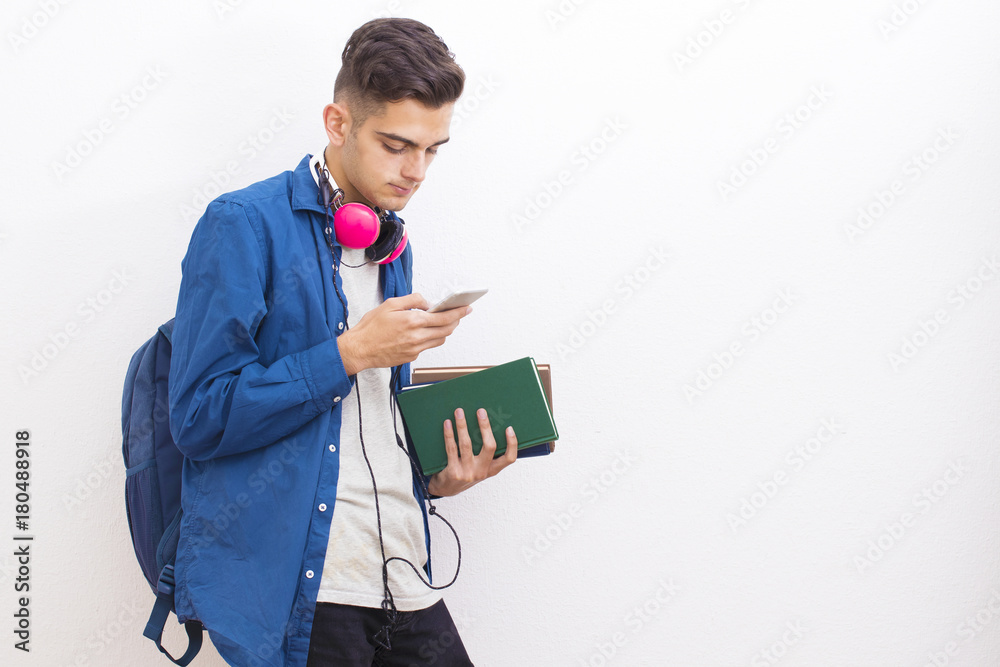 college adolescent student with books and mobile phone on wall background college adolescent student with books and mobile phone on wall background