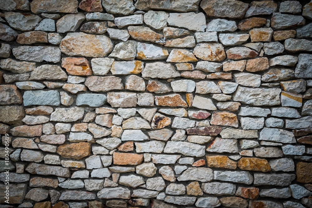 Stone wall background of colorful stones with vignetted borders Stone wall background of colorful stones with vignetted borders