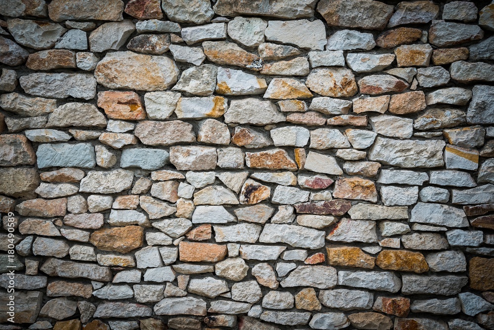 Stone wall background of colorful stones with vignetted borders