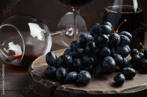 Fresh Black Grapes and Red Wine on Wooden Table Selective Focus