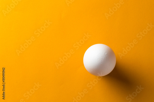 White egg and egg yolk on the yellow background. topview