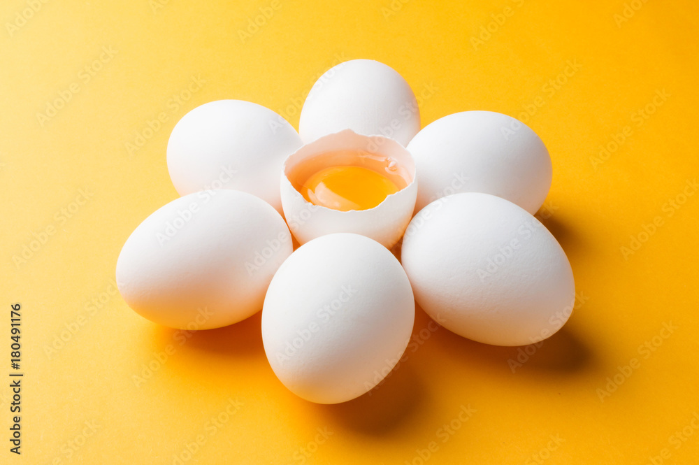 White eggs and egg yolk on the yellow background White eggs and egg yolk on the yellow background