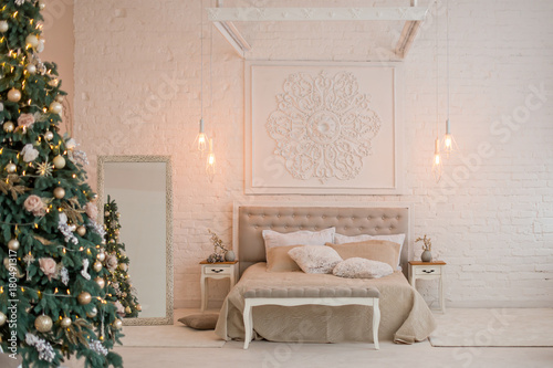 New Year's interior. Christmas tree bed with soft blue back and decorative pillows, large floor mirror. Concept happy Xmas