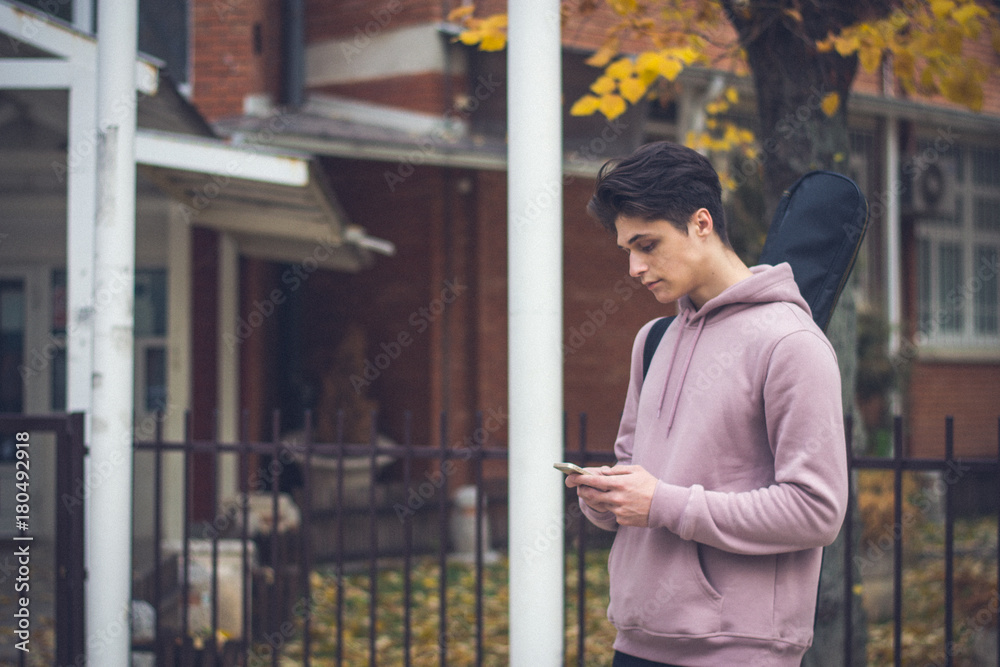 young student with smartphone and guitar young student with smartphone and guitar