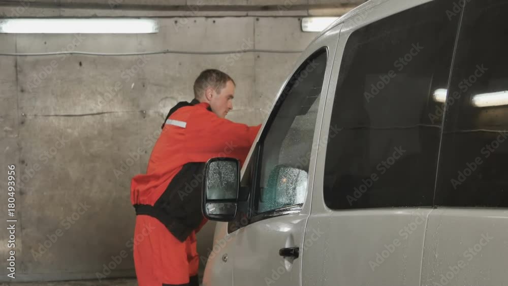 Worker polishes car with wax spray Worker polishes car with wax spray