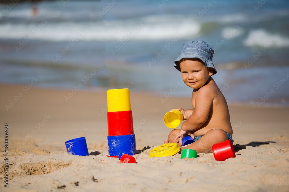 Kid plays with toys at the seashore in summertime Kid plays with toys at the seashore in summertime