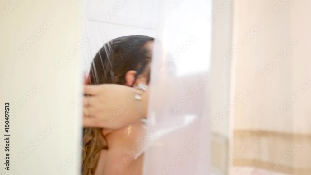 Caucasian Woman showers in shower stall and washes her hair Caucasian Woman showers in shower stall and washes her hair