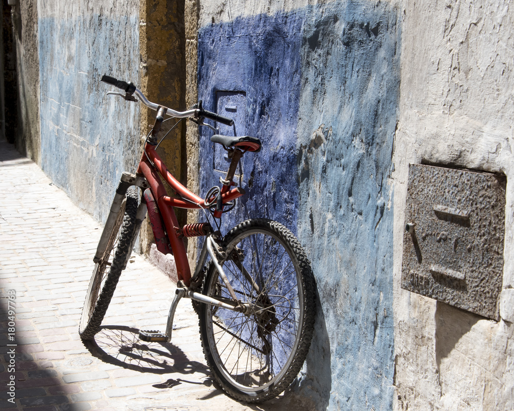 Old bike in a patch of sunlight, leaning against an Alley wall of the Medina