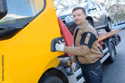 Canvas Print portrait of a tow truck woker with a towed car