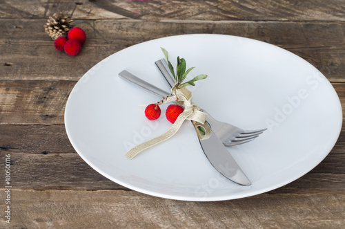 Plate with Christmas decoration on wooden background.