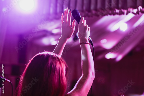 Microphone in female hands close-up. A pub. Bar. A restaurant. Classical music. Evening. Night show.