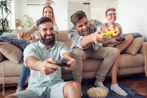 Beautiful couples playing video games on console photo