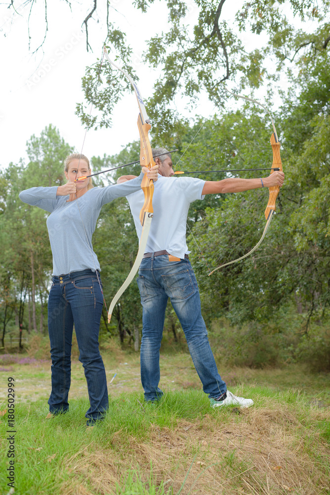 Couple practicing archery Couple practicing archery