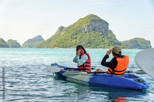 Two women are mother and daughter using a camera take pictures on kayak while travel by boat with happy on the sea at Ko Wua Ta lap islands in Mu Ko Ang Thong National Park, Surat Thani, Thailand
