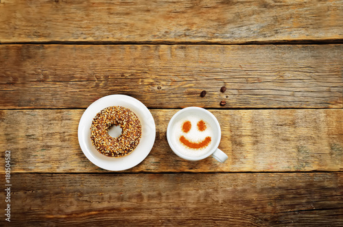 Wood background with cup of coffee and donut