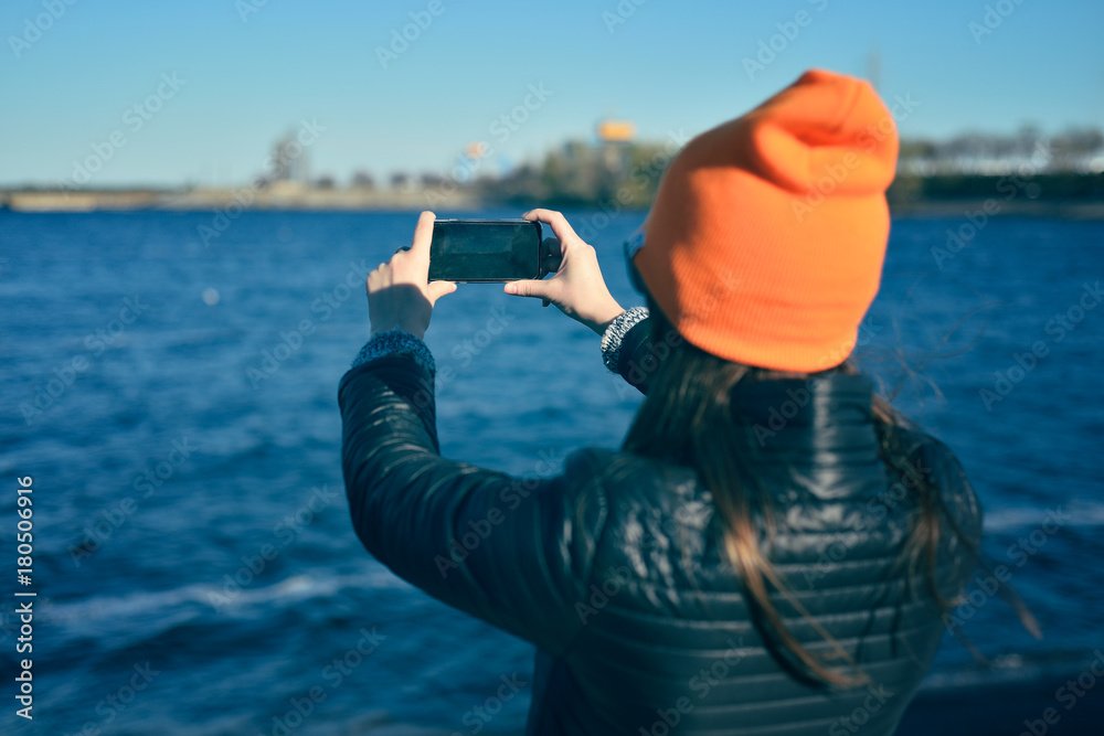 The girl is taking a photo of the river