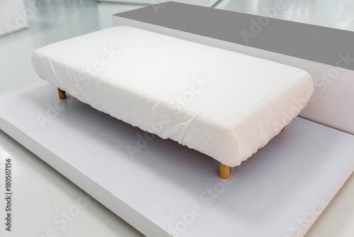 Fotografie Brand new sofa bed with white cover fitted sheet and wooden leg