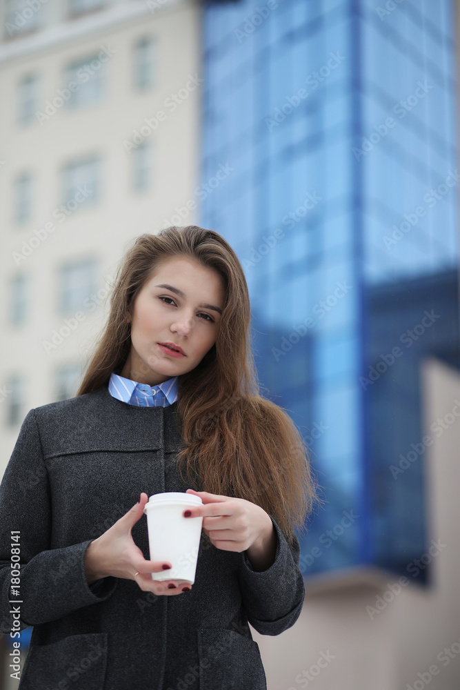 young girl with a paper cup of coffee outdoors