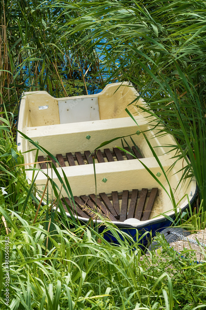 Naklejka premium old plastic boat forgotten in the grass