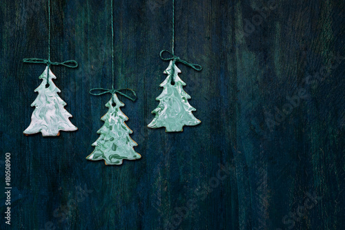 hanging christmas tree cookies on a wooden background