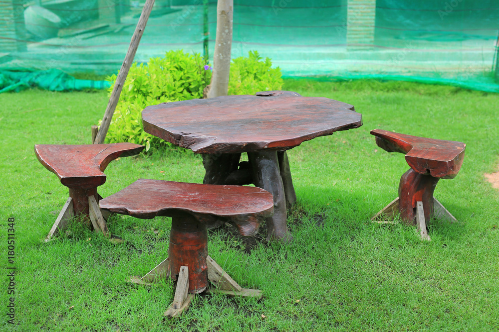 Wooden table and chairs in the green garden.