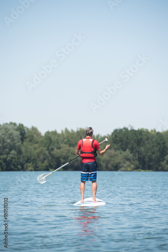 man enjoying a ride on the lake with paddleboard