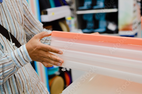 Close up image of person choosing selecting container on the indoors background. Buying, checking, preparing celebration, wholesale fabric production