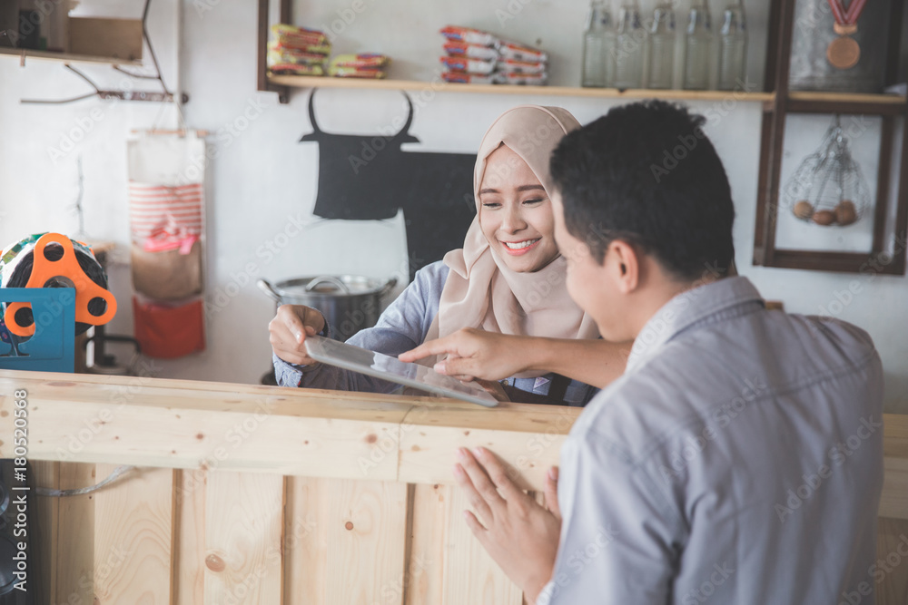 female waitress showing the menu to her customer