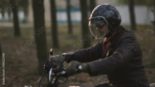 Man Riding old custom cafe-racer Motorcycle on Country Road at sunset 