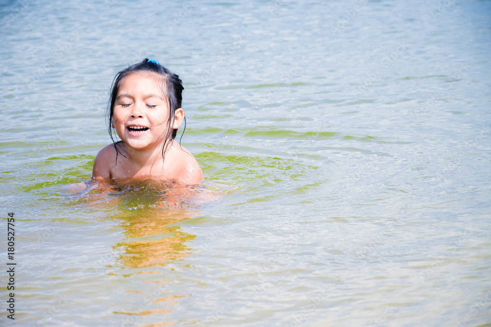 Happy little latin girl in the water