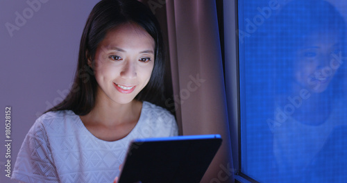 Woman looking at tablet computer in the evening