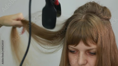 Professional Hair Dresser Used Hair Curler Iron for brunette Hair at beauty salon