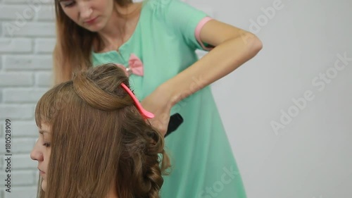 Professional Hair Dresser Used Hair Curler Iron for brunette Hair at beauty salon