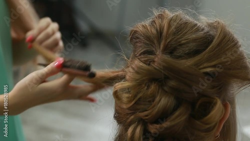Professional Hair Dresser Used Hair Curler Iron for brunette Hair at beauty salon